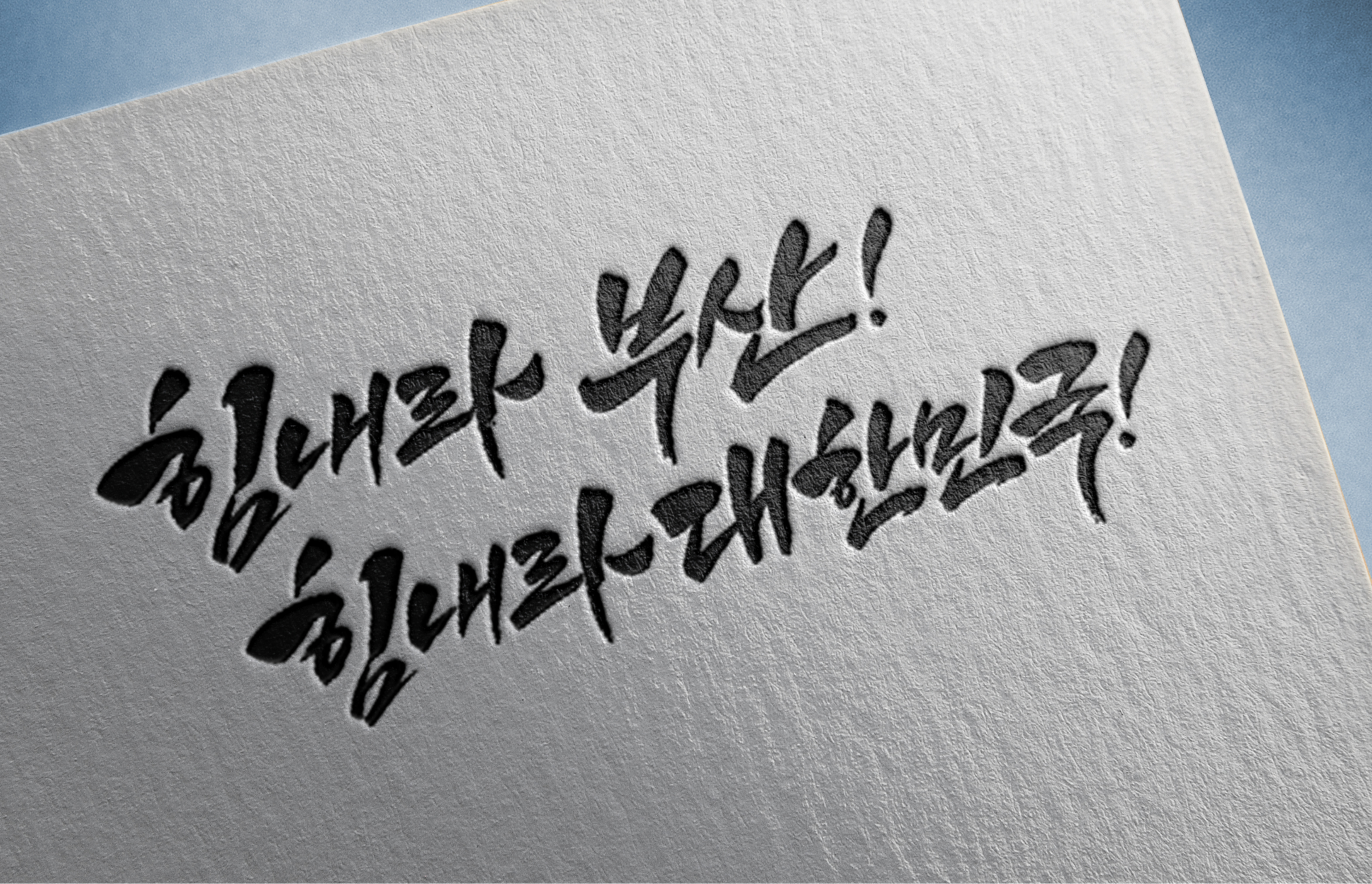 흰 종이 위에 검은색 붓글씨로 한글 문구가 적혀 있다