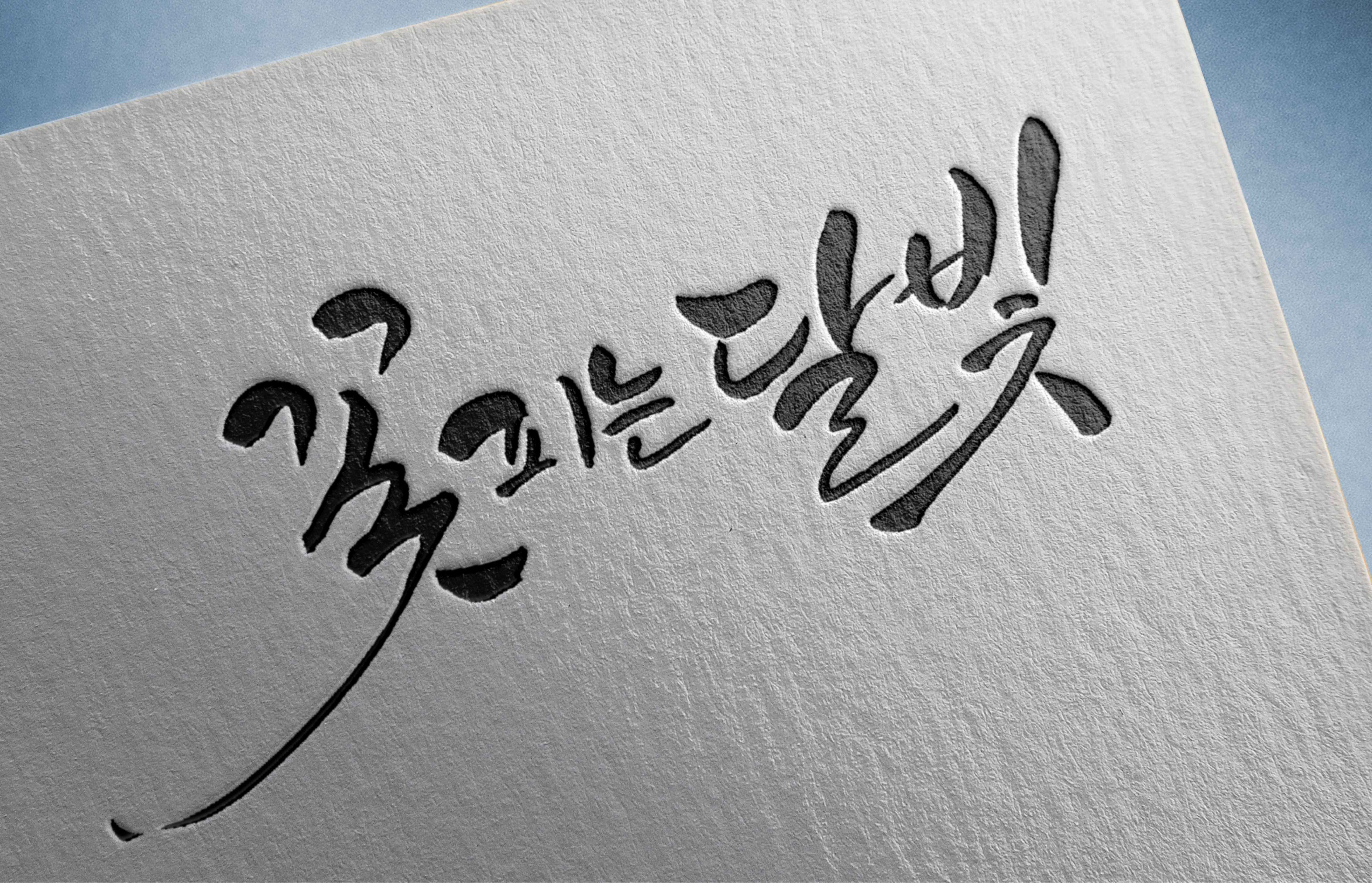 흰 종이에 검은색 붓글씨로 한글 문구가 적혀 있다.