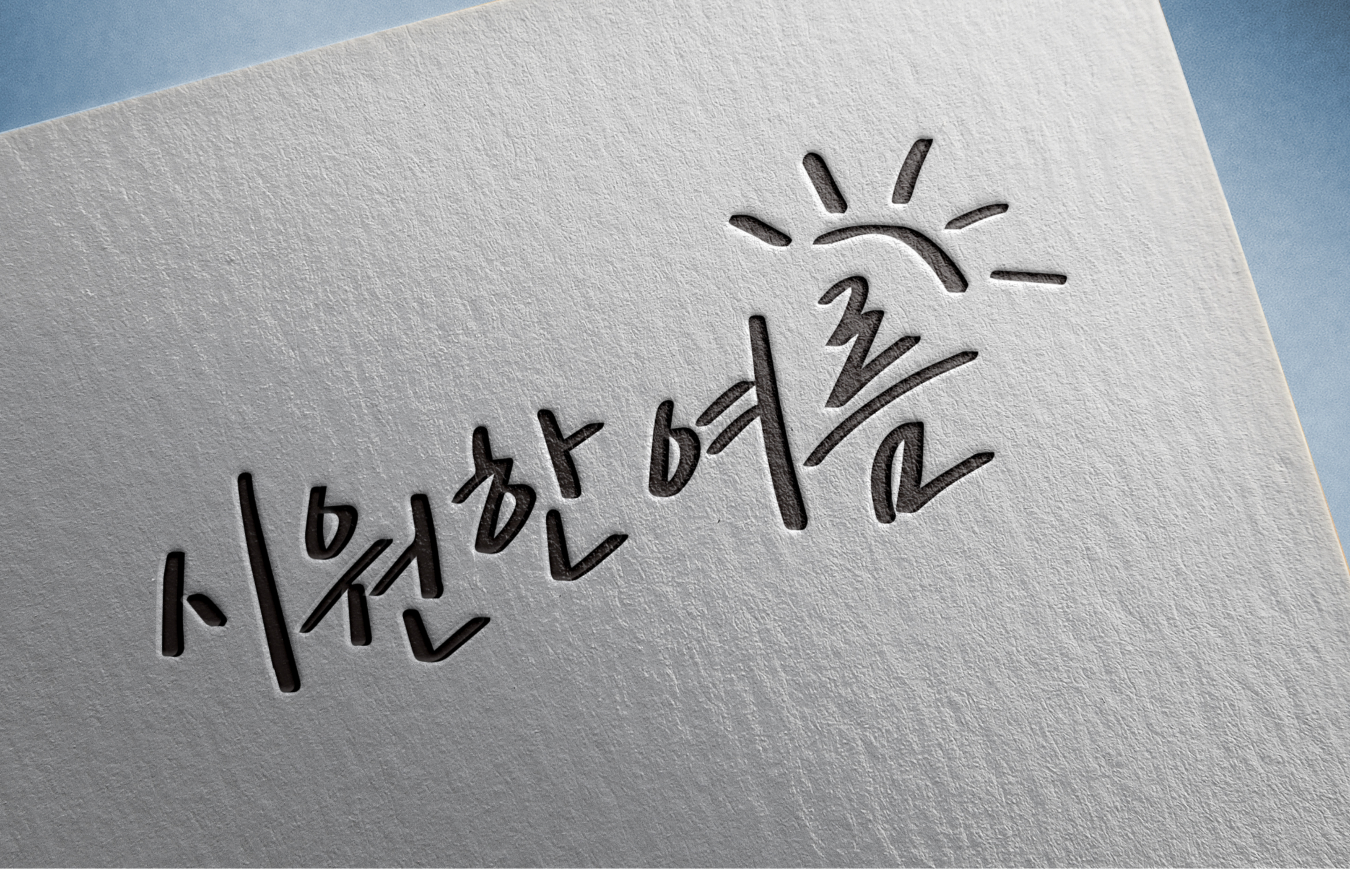 흰색 종이 위에 검은색으로 쓰인 손글씨와 해 모양의 그림이 보인다.