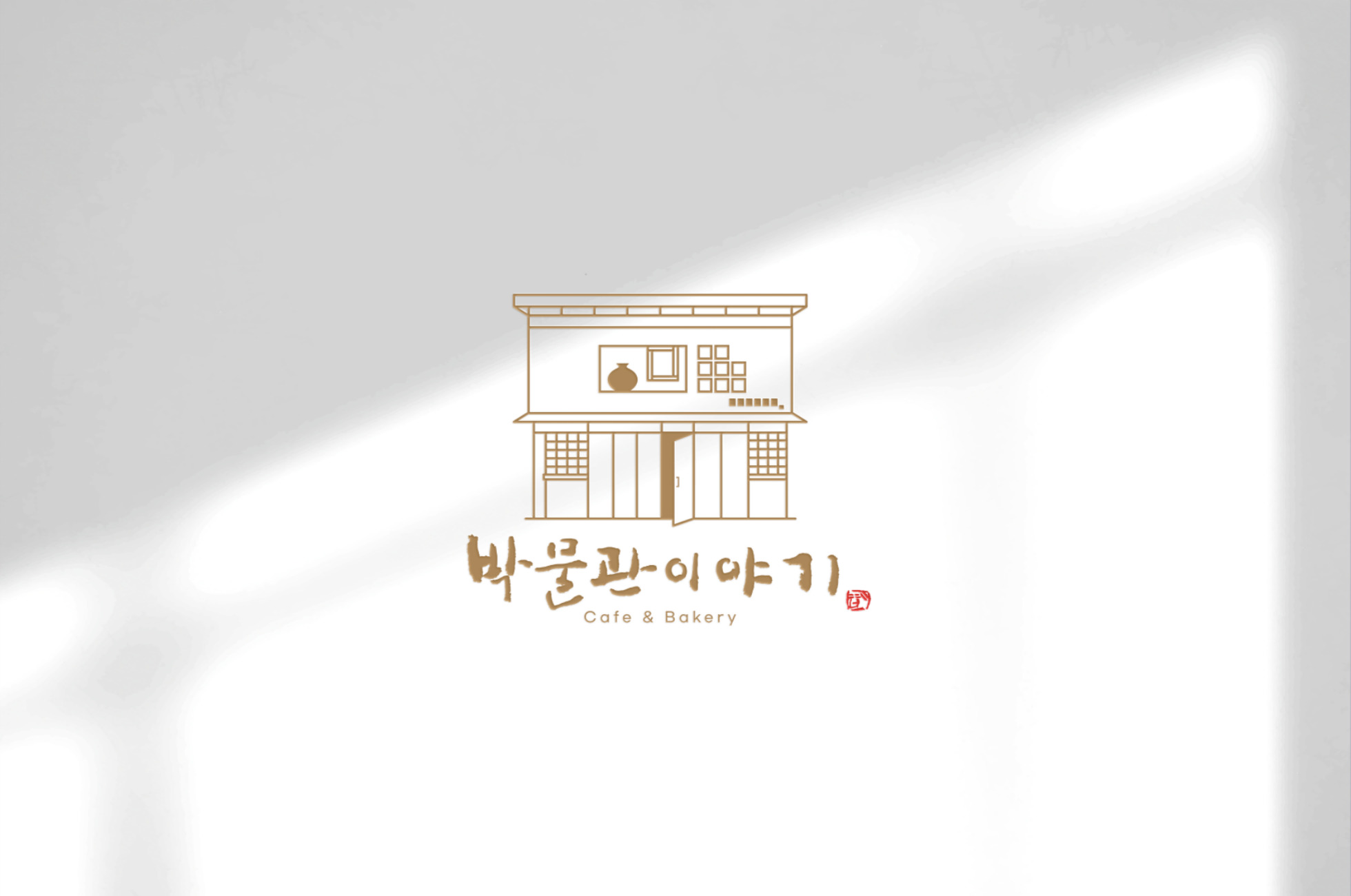 흰색 배경 위에 카페 건물 일러스트와 ‘박물관이야기 Cafe & Bakery’ 로고가 보인다.